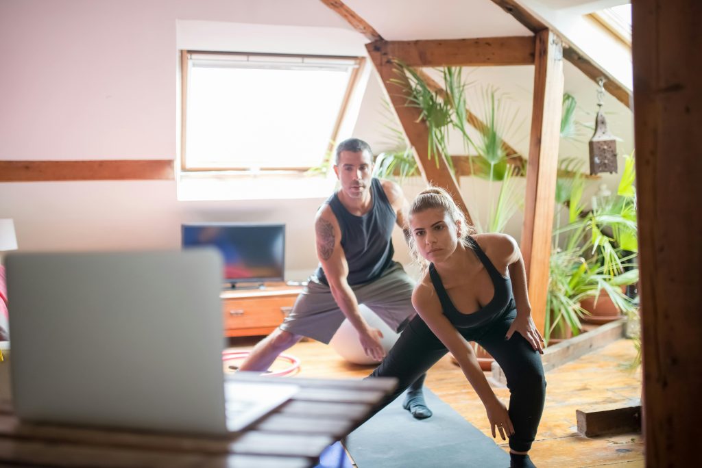 People working out while looking at a laptop