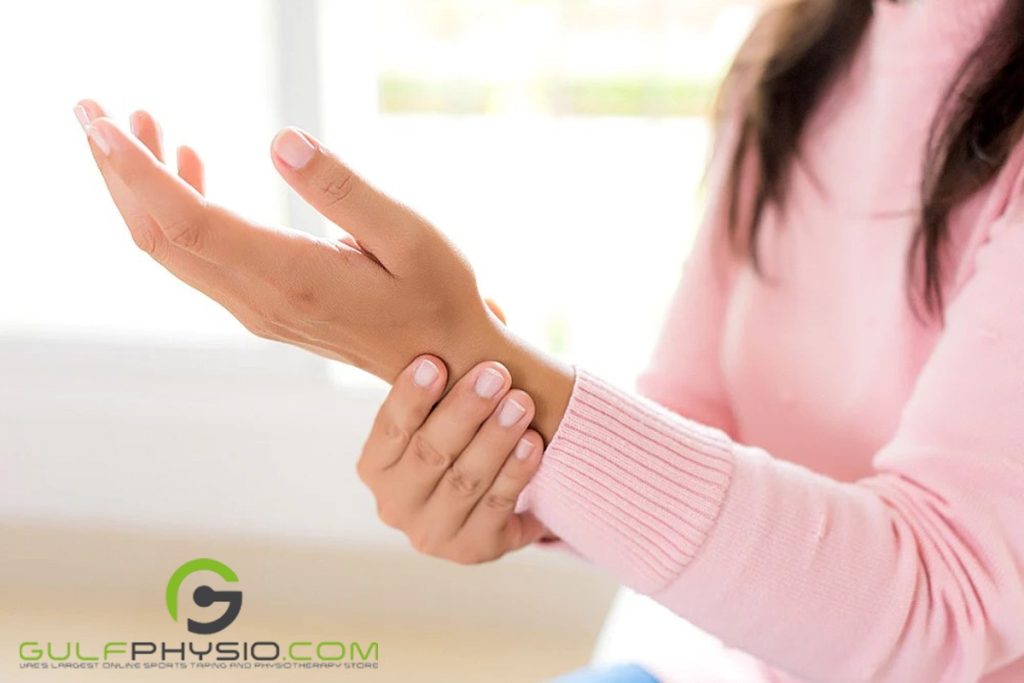 A woman holding her stiff wrist