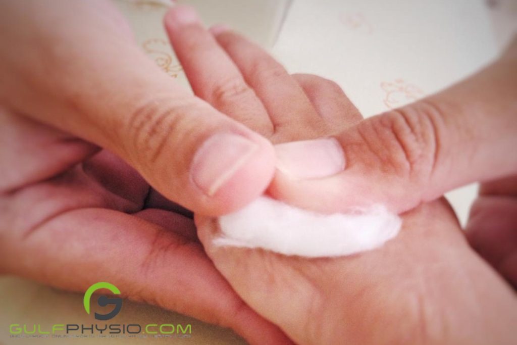 A person putting a bit of a paraffin wax on another person's hand for their minor cut