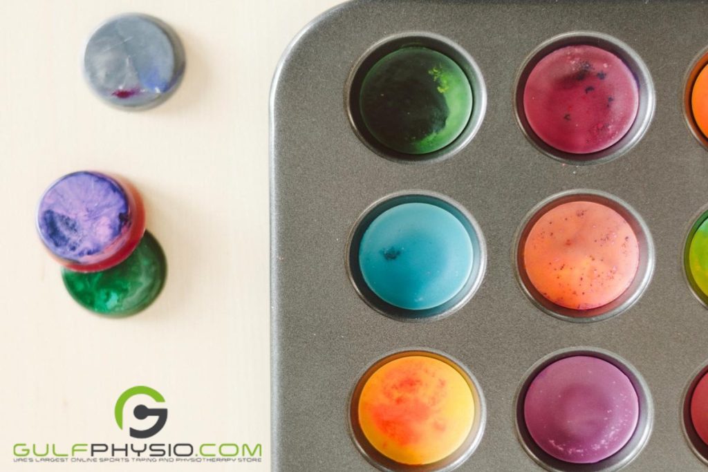 A tray of homemade crayons and modeling clay on a table