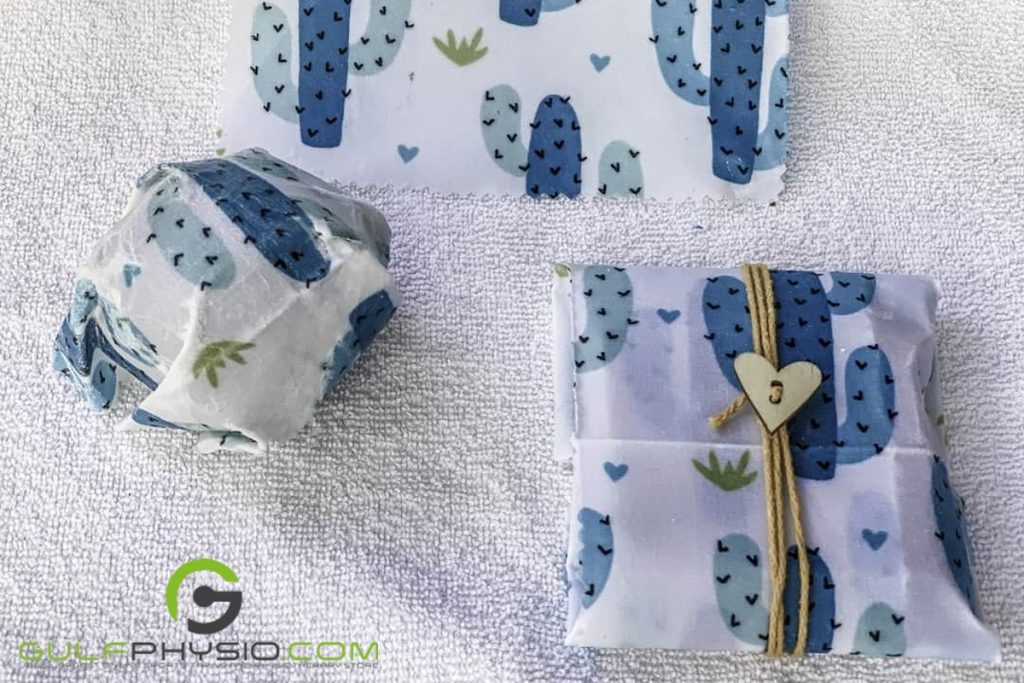 Handmade food wraps with blue cacti on them wrapping food with ties while on a table