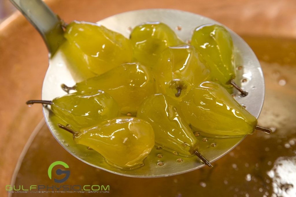 A bunch of fruit submerged and then lifted from a vat of melted paraffin wax