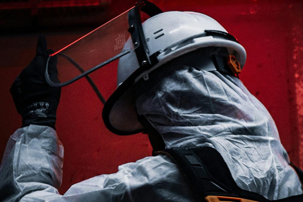 A person is getting ready for an emergency by suiting up protective gear like a face shield and a helmet