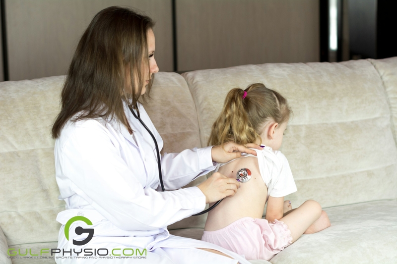 A pediatric doctor conducting a check-up on a young girl. The doctor is listening intently, as her stethoscope is placed on the young patient's back.