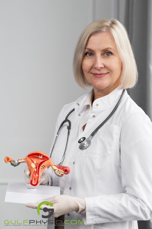 An older female doctor holding a model of the uterus.