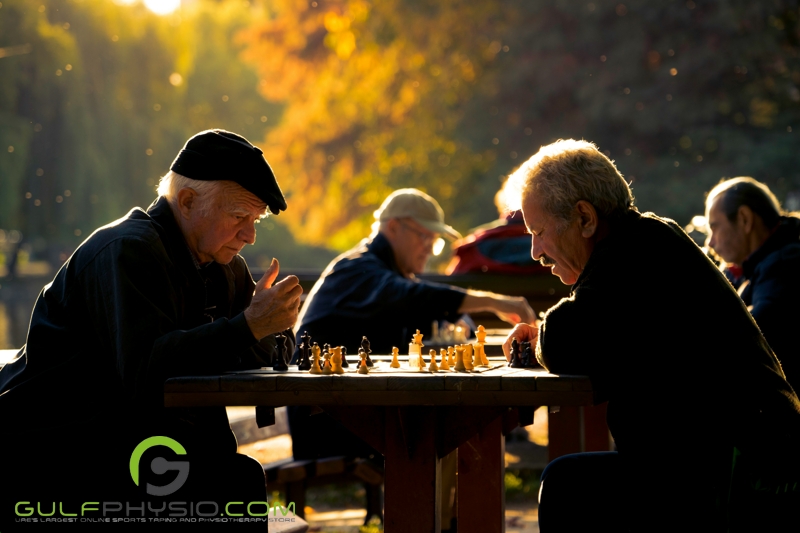 Two men playing chess in the park.