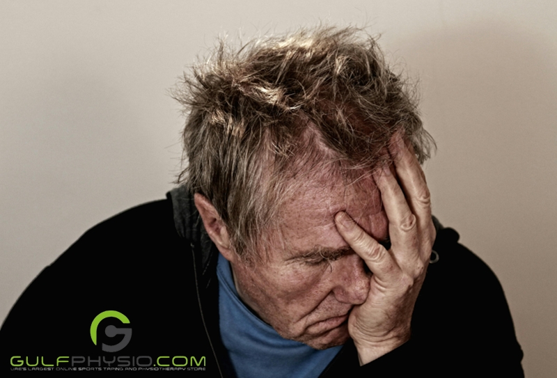 An older man covering part of his face with his left hand. He looks disheveled and stressed out.