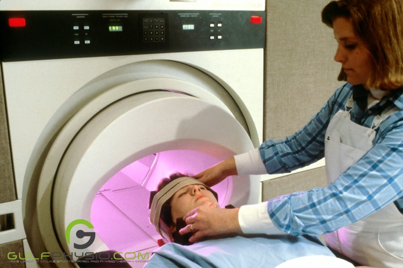 A woman is being prepared for an MRI scan, and a nurse is adjusting her head placement for comfort