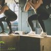 A close-up image of two gym enthusiasts doing box jumps on jump boxes at the gym.